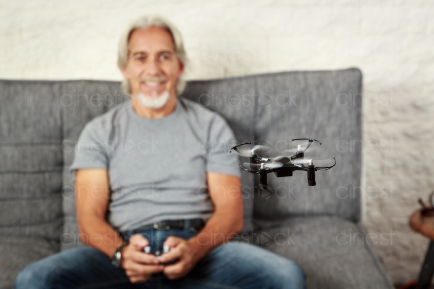 Mann auf Sofa spielt mit Drohne  20160809-0384