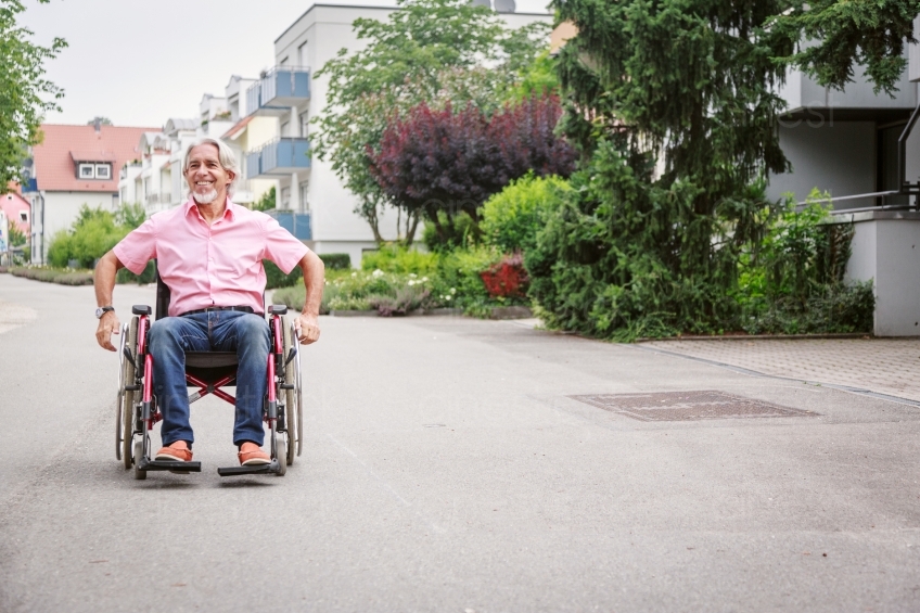 Mann fährt Rollstuhl an Straße 20160725-0470