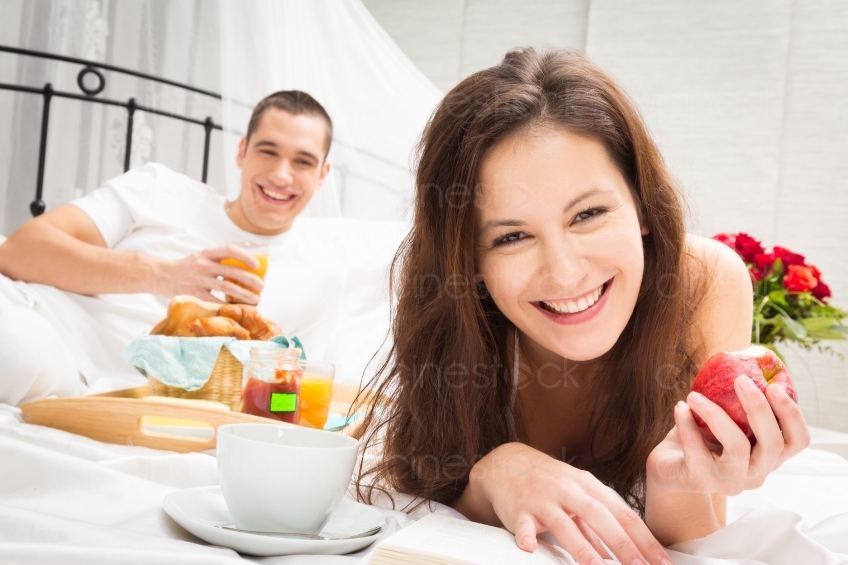 Mann Frühstückt im Bett und Frau liest 20121130