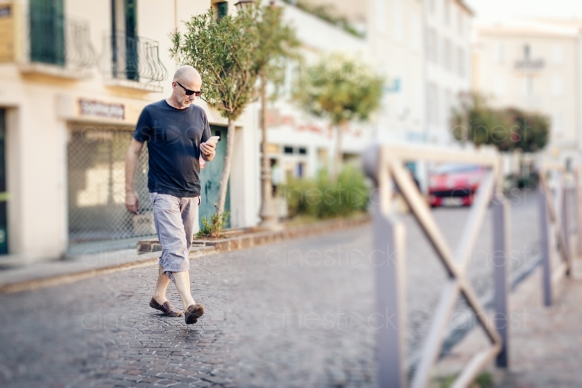 Mann geht mit Handy in der Hand spazieren 20160823