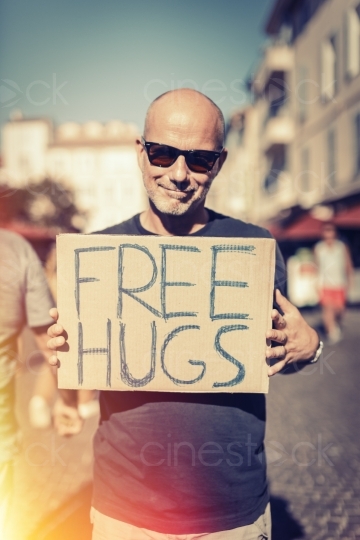 Mann hält "Kostenlose Umarmungen" Plakat in den Händen 20160823