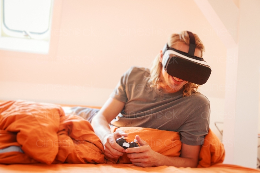 Mann liegt mit VR Brille im Bett 20160810