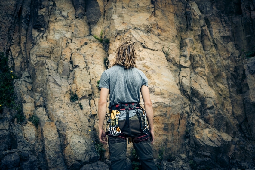 Mann mit Kletterausrüstung vor einem Berg 20160718