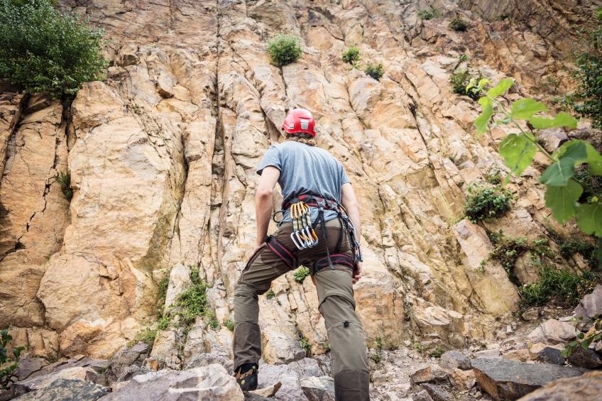 Mann mit Kletterausrüstung vor einem Berg 20160718