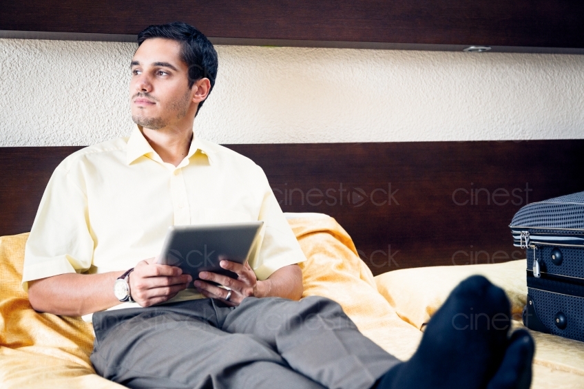 Mann sitzt an Tablet 