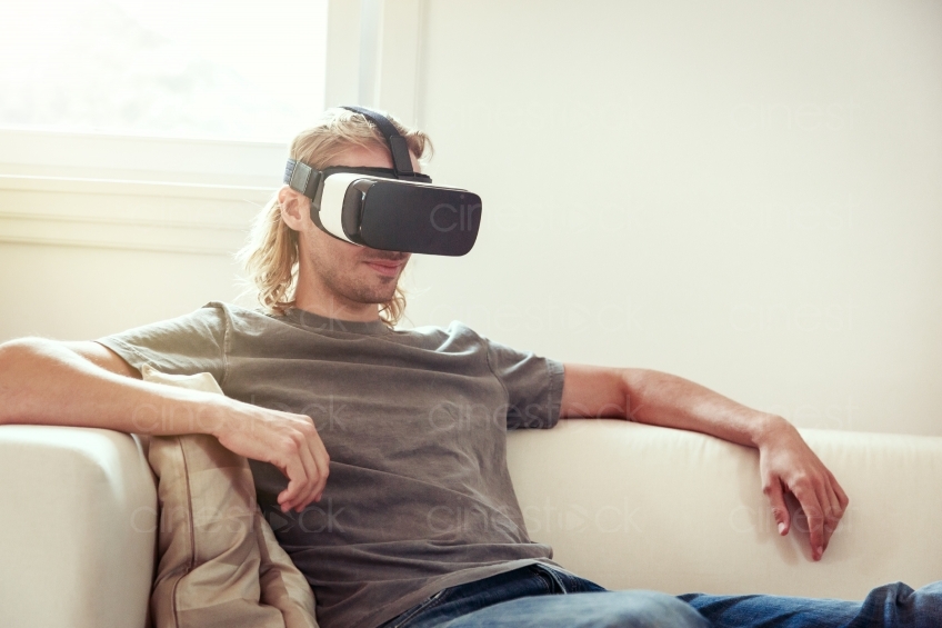 Mann sitzt mit VR-Brille auf dem Sofa 20160810