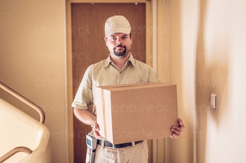 Mann steht vor einer Tür mit Paket 20160823