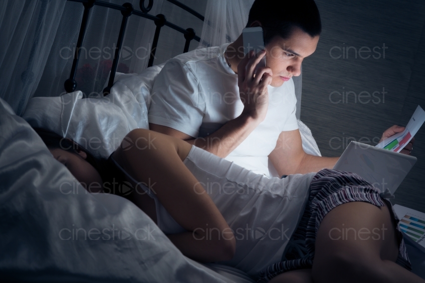 Mann telefoniert im Bett 20121130-464 