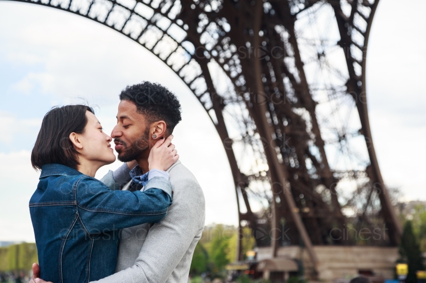 Mann und Frau küssen sich vor dem Eiffelturm 20160426