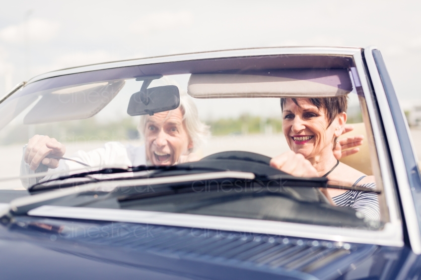 Mann zeigt Frau etwas bei Fahrt in Cabrio 20150429-0352