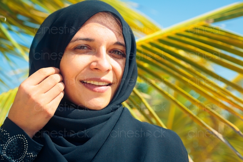 Muslima lächelnd im Profil vor Palme 20140313-3911