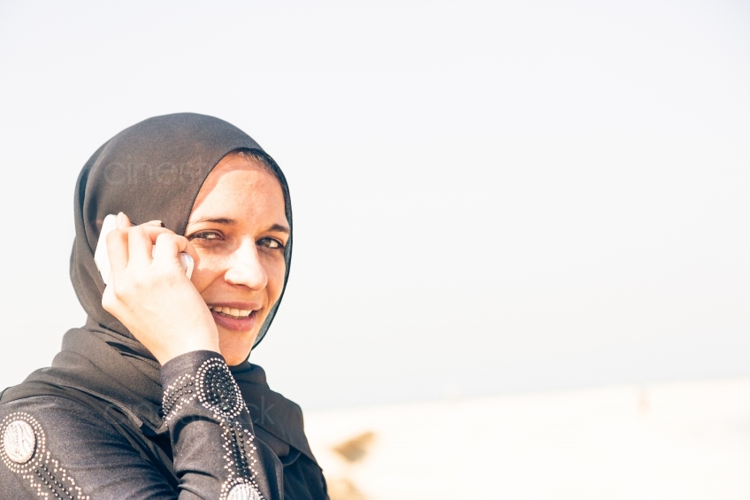 Muslima mit Handy schaut in Kamera 20140313-3771