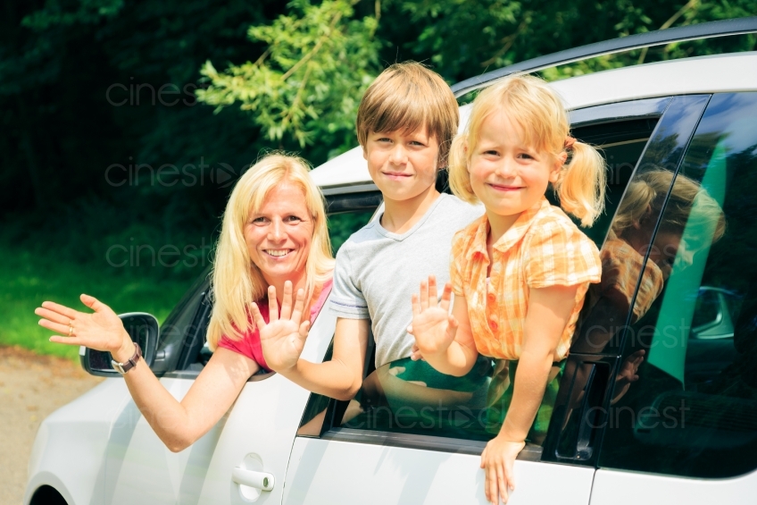 Mutter und Kinder winken aus Auto 20120810-894