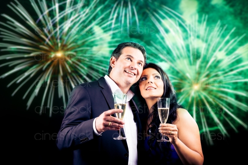 Paar mit Gläsern vor Feuerwerk grün20120814-85