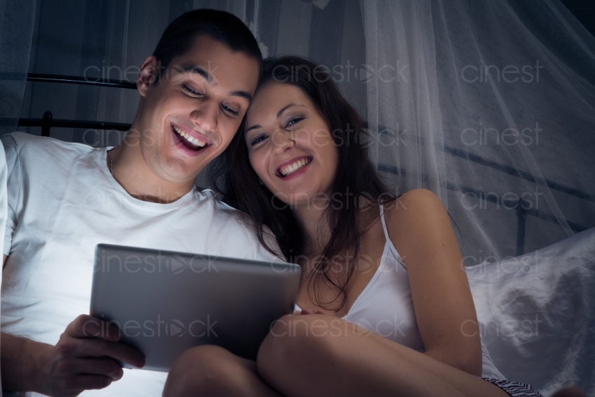 Paar schaut im Bett aufs Tablet 20121130-418
