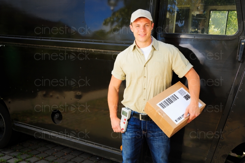 Postbote vor Transporter mit Paket im Arm 20120809