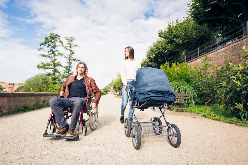 Rollstuhlfahrer mit Kinderwagen und Frau bei Spaziergang 20160810-0244 