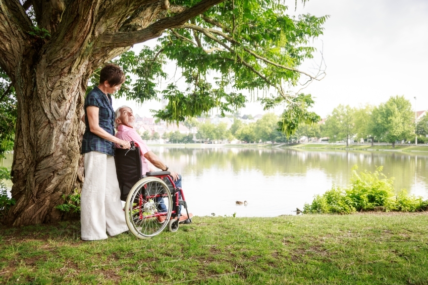 Rollstuhlfahrer und Frau an See sehen sich an 20160725-0081