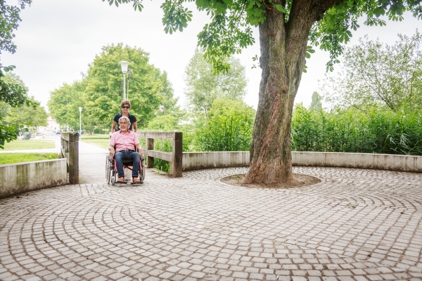 Rollstuhlfahrer und Frau mit Sonnenbrille im Park 20160725-0216 