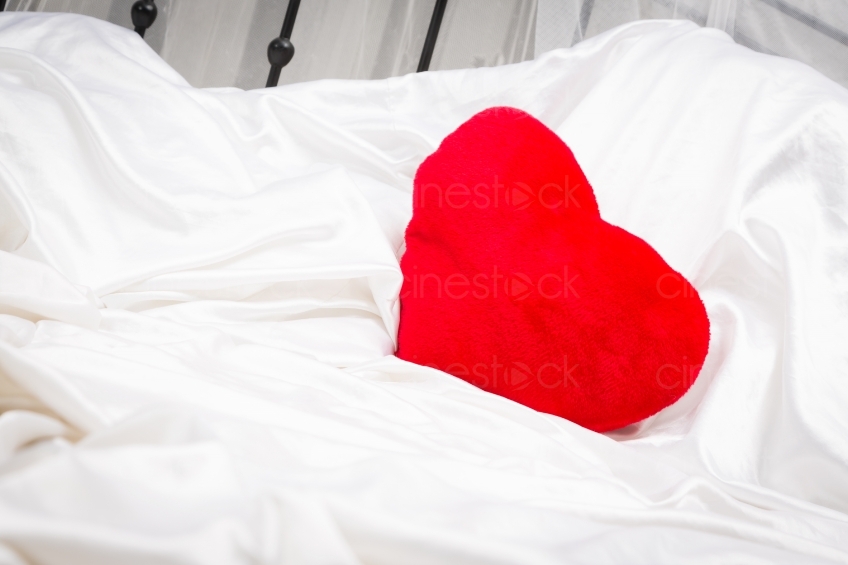 Rotes Herzkissen in einem Bett 20121130
