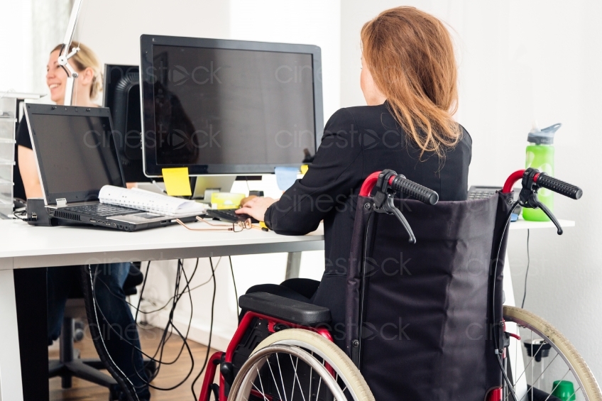 Rückenansicht von Rollstuhlfahrerin an Arbeitsplatz 20150510-0087 