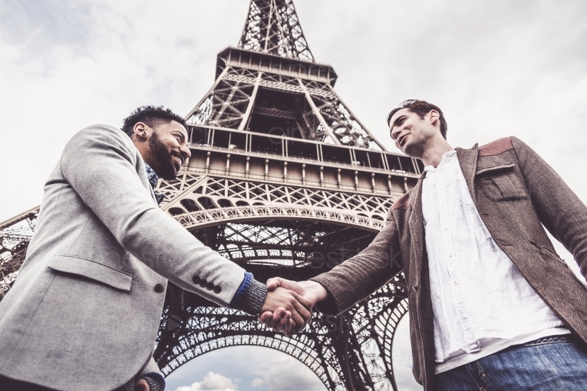 Zwei Männer reichen sich vor dem Eiffelturm die Hände 20160426